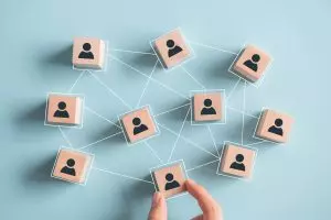 Building a strong team, Wooden blocks with people icon on blue